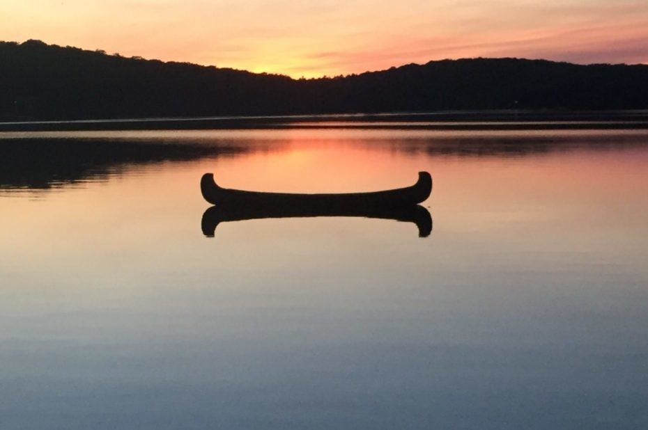 Canoe on lake at sunset