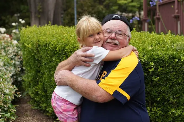 A grandfather hugging a young girl
